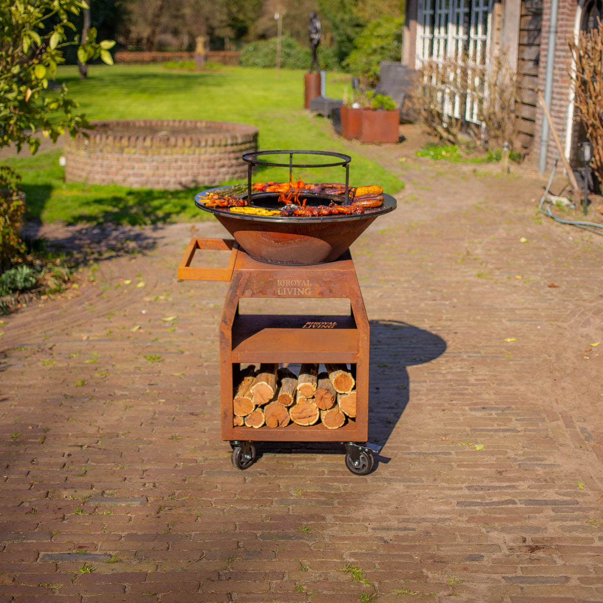 BBQ Plancha Grill Maestro Ø70cm Acero Corten - Con ruedas grandes y almacenamiento de leña