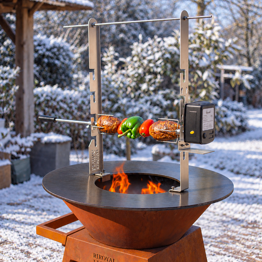 RVS rotisserieset met motor en spit gemonteerd boven een plancha in wintertuin